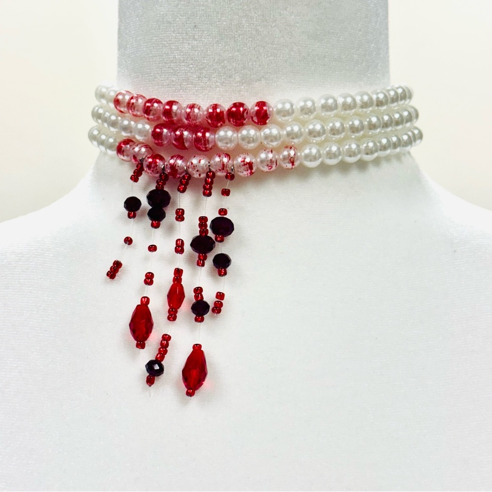 Red and white pearl choker necklace with a touch of gothic flair